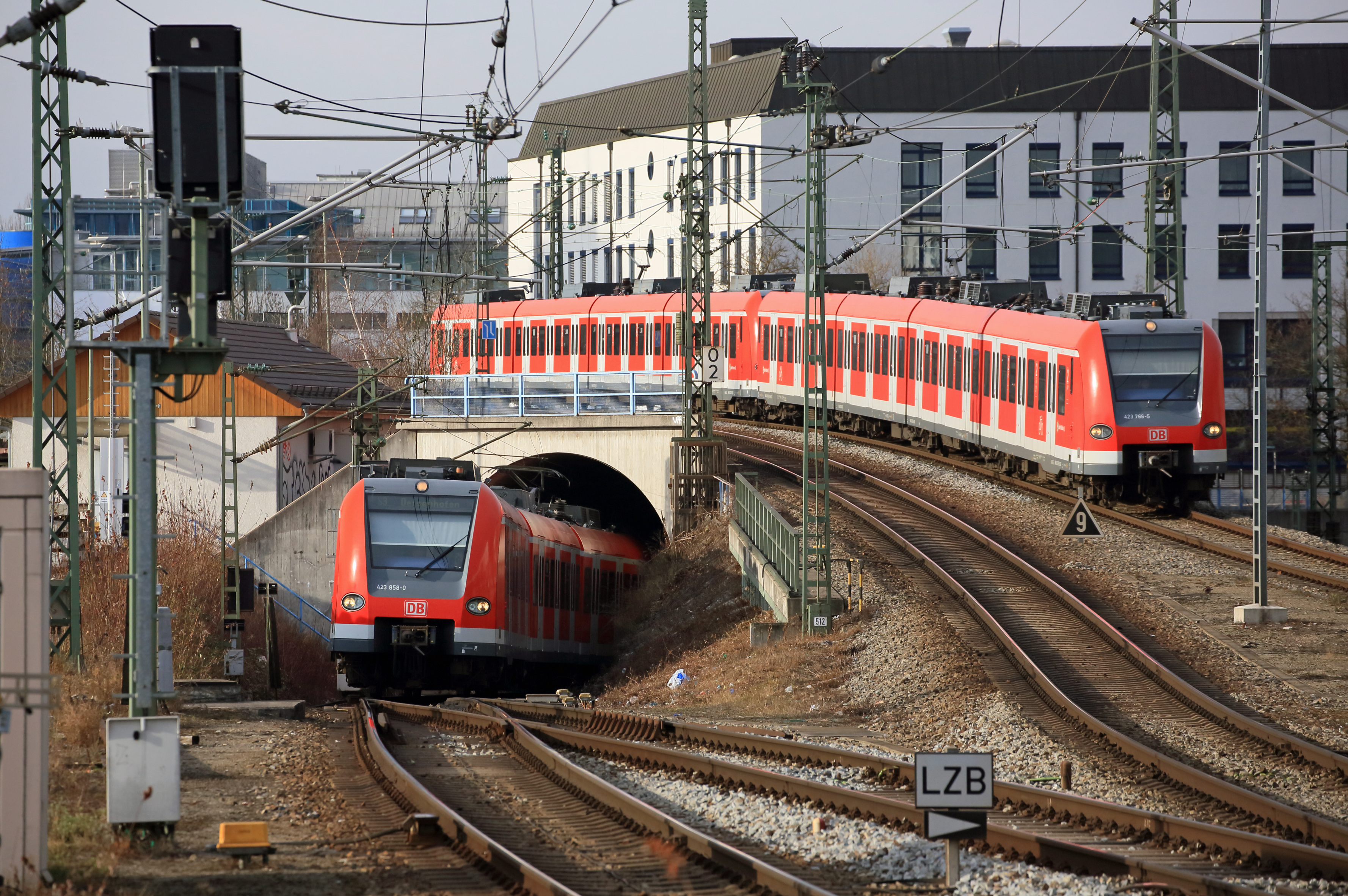 Eine S-Bahn kommt aus dem Tunnel, eine andere kreuzt auf der Brücke